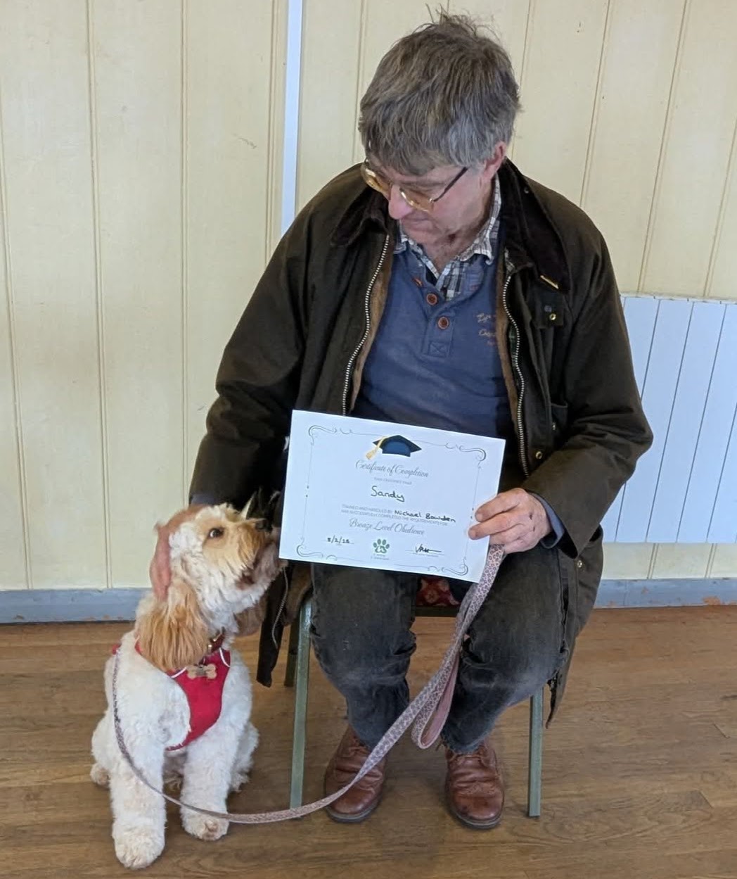 Trainer celebrating a young dog completing their obedience certificate